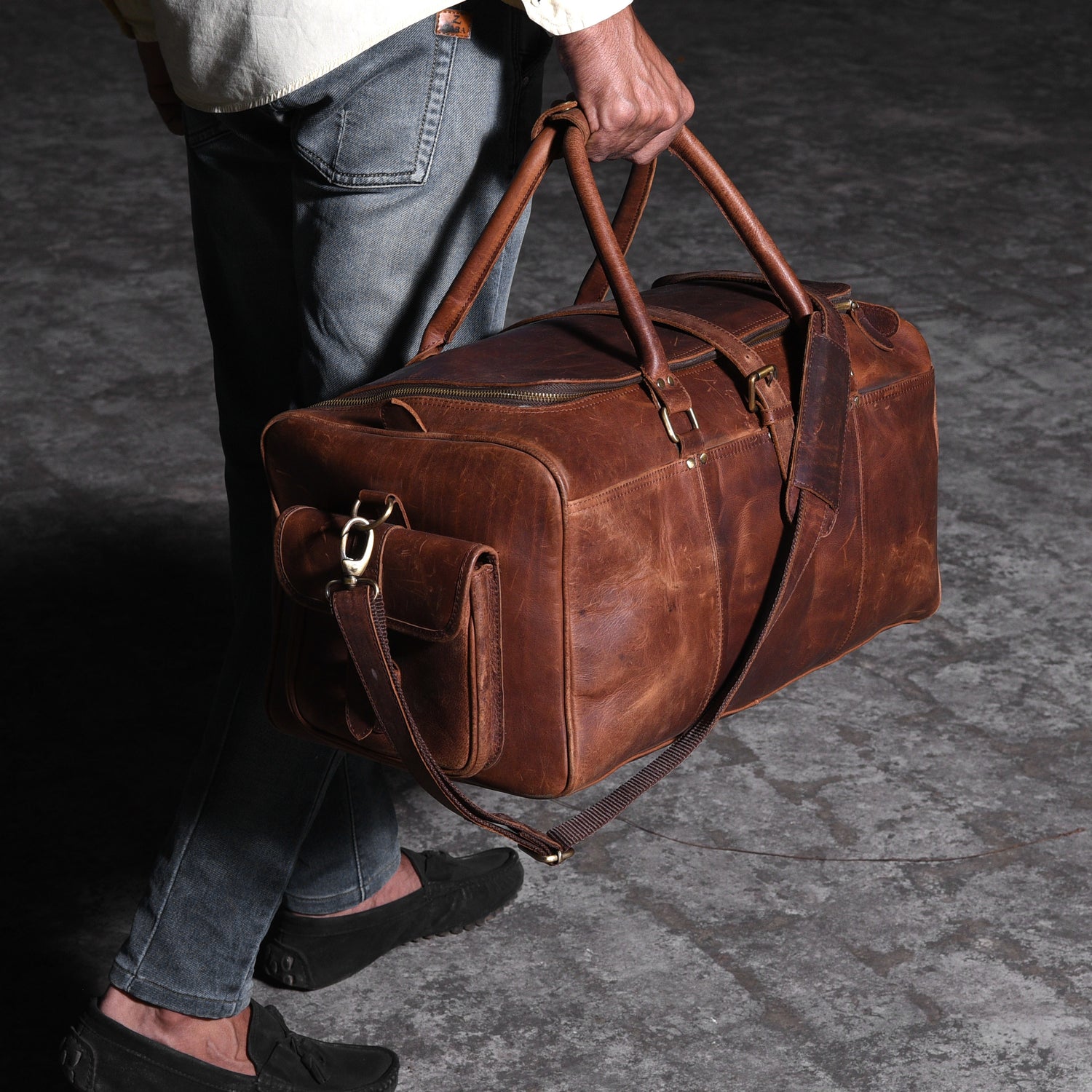 man-walking-with-a-leather-travel-bag - VILL OKSE